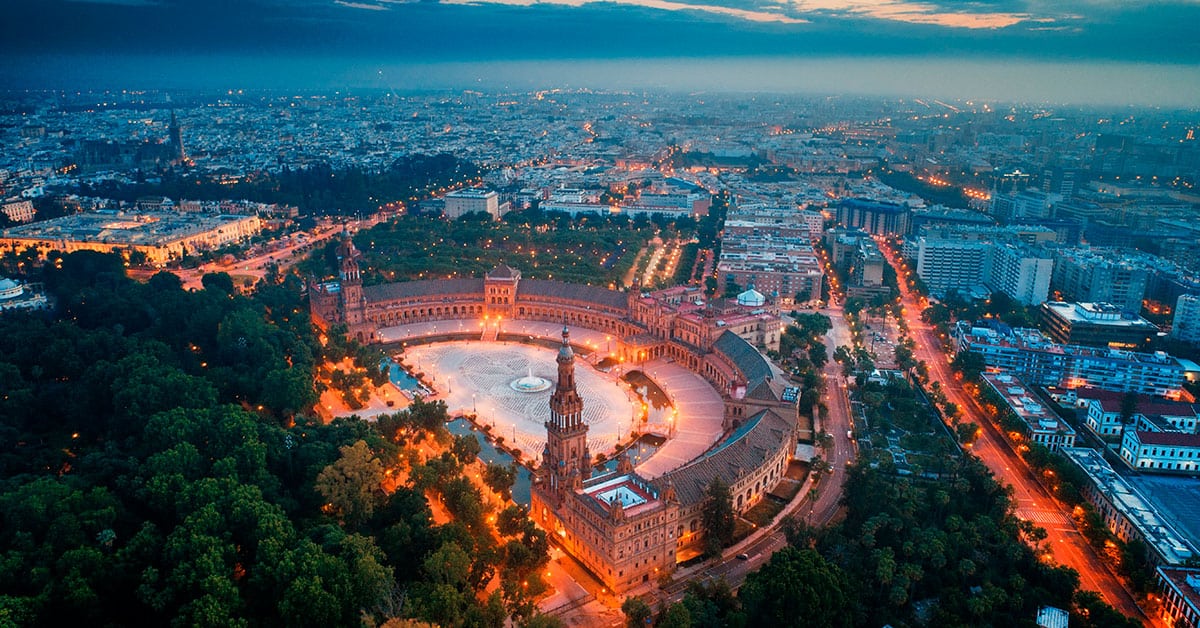 ¿Cuánto cuesta un piso en Sevilla? Depende. Y mucho. El metro cuadrado no vale lo mismo en una finca del casco histórico que en un bloque de Pino Montano, y entre los dos puede haber una diferencia de mil euros por metro. Quien quiere comprar o invertir en la capital andaluza necesita una cosa antes que ninguna otra: saber leer el precio por m². Esta guía repasa lo que de verdad importa —cuánto se paga según la zona, cómo calcular el coste de un piso a partir de su superficie, qué pesa en la valoración y hacia dónde apunta el mercado—. Sevilla lleva años de subidas suaves, sin las burbujas de la costa y sin los precios prohibitivos de Málaga. ¿Cuál es el precio medio de venta de pisos en Sevilla capital? Precio por m² actualizado en Sevilla capital El metro cuadrado es la unidad que manda. Es el dato que permite comparar un piso con otro, calcular si una oferta está cara o tirada, y entender de un vistazo cómo respira el mercado. En Sevilla capital ese precio se mueve dentro de un rango competitivo para lo que es Andalucía, con una trayectoria estable que el índice inmobiliario de Fotocasa y otras fuentes confirman año tras año. La capital hispalense no da sustos: el precio medio varía según el distrito, pero se mantiene accesible para presupuestos muy distintos. Los ajustes que ha vivido el sector responden tanto a la demanda local como a lo que pasa en el resto del país. Diferencias de precio entre zonas de la ciudad Aquí está la clave de todo. La zona decide. Los barrios del centro histórico cobran un metro cuadrado más alto por ubicación y por el encanto de sus edificios viejos, mientras que las áreas alejadas del núcleo ofrecen precios más amables, ideales para familias que buscan metros sin renunciar a calidad de vida. Nervión, Triana, Los Remedios, la Macarena: cada barrio tiene su carácter y su valoración. Las zonas en expansión y los desarrollos nuevos lanzan precios competitivos que enganchan al comprador joven; las consolidadas mantienen valores más altos pero firmes. Esa horquilla tan ancha es justo lo que hace que el mercado sevillano tenga sitio para casi todos los bolsillos. Comparativa del precio medio con otras ciudades andaluzas Comparada con sus vecinas, Sevilla queda en un punto intermedio que la favorece. El metro cuadrado sale más barato que en Málaga, donde el turismo dispara los valores. Pero está por encima de Jaén o Córdoba, lo que tiene su lógica: hablamos de la capital autonómica y del motor económico de la región. Esa posición de en medio la vuelve atractiva para quien busca rentabilidad sin pagar los precios de la costa. Y la provincia añade otra capa: municipios cercanos con alternativas más económicas y buena conexión con la capital. En conjunto, una relación calidad-precio difícil de igualar en el sur peninsular. ¿Cómo calcular el precio de compra de pisos en Sevilla según los m²? Fórmula para determinar el precio de la vivienda por m² La cuenta es sencilla, casi de servilleta: precio por metro cuadrado de la zona multiplicado por los metros del piso. Un ejemplo. Si en un punto de Sevilla capital el metro está a 2.000 euros y la vivienda tiene 80 m², el coste ronda los 160.000 euros. Con esa cifra ya puedes comparar pisos entre sí y ver si lo que piden cuadra con el mercado o se han venido arriba. Ojo a los extras —terraza, trastero, plaza de garaje—, que mueven el número. Dominar esta fórmula te da una herramienta rápida para saber, casi de un vistazo, si un anuncio merece una visita o no. Factores que influyen en el precio por m² en el mercado en Sevilla Son muchos los elementos que empujan el metro cuadrado arriba o abajo. El primero, sin discusión, la ubicación: cerca de servicios, transporte y comercio, el precio sube. El estado del edificio y del piso cuenta también, y bastante; una vivienda reformada se vende por encima de la media de su barrio. Suman la orientación, la luz, la planta y tener ascensor o no tenerlo. A esto se añaden los factores grandes, los que no dependen del piso: cómo van los tipos de interés, qué oferta de vivienda hay disponible, hacia dónde se mueve la demanda. Y un detalle que la gente olvida: la reputación del barrio. Seguridad, equipamientos, ambiente. Todo eso se cuela en el precio aunque no figure en el anuncio. Ejemplos prácticos de cálculo de precio de venta en Sevilla Vamos con números reales. Un piso de 70 m² en el centro histórico, con el metro cuadrado en 2.500 euros, te sale por unos 175.000 euros. La misma vivienda, 70 m² también, pero en una zona periférica donde el metro está a 1.500, baja a unos 105.000. Casi la mitad. ¿Y uno de 100 m² en un barrio de demanda media, con el metro a 1.800? Alrededor de 180.000 euros. Estos cálculos sirven para una cosa muy concreta: poner expectativas realistas y negociar con argumentos en la mano. Quien llega a una negociación sabiendo el precio medio de la zona parte con ventaja sobre quien va a ciegas. ¿Qué diferencia hay entre el precio de venta y el precio de alquiler en Sevilla? Comparativa precio de alquiler por m² versus precio de compra Comprar o alquilar. La eterna duda. La renta mensual suele rondar entre el 0,4% y el 0,6% del precio de compra, aunque la cifra baila según la zona y el tipo de piso. Para que se vea: mientras el metro cuadrado en compra oscila entre 1.500 y 3.000 euros en la capital, el alquiler mensual por metro se queda entre 6 y 12 euros. Traducido a un caso concreto, un piso de 80 m² que cuesta 160.000 euros se alquilaría por unos 600-800 euros al mes. El alquiler da flexibilidad y no exige soltar una entrada de golpe; comprar acumula patrimonio con los años. Dos respuestas para dos situaciones distintas, y ninguna es la correcta en abstracto. Rentabilidad de casas y pisos en Sevilla para inversión Aquí es donde se anima el inversor. La rentabilidad bruta anual de un piso destinado a alquiler en Sevilla se sitúa entre el 4% y el 6%, según ubicación y características. El cálculo es directo: ingresos anuales por alquiler divididos entre el precio de compra, por cien. Una vivienda comprada por 150.000 euros que se alquila a 700 al mes genera 8.400 euros al año, o sea, un 5,6% de rentabilidad. Suma a eso una demanda de alquiler estable —estudiantes, profesionales que llegan a la ciudad— y la revalorización que el precio ha ido acumulando, y entiendes por qué el ladrillo sevillano compite bien con otros productos financieros. Con la ventaja, no menor, de poseer un activo que puedes tocar. Precio de alquiler en Sevilla según ubicación y características El alquiler sigue el mismo guion que la compra, con sus matices. Las zonas más buscadas —centro histórico, Nervión, Los Remedios— cobran un metro cuadrado de alquiler muy por encima de la periferia. Un piso en el centro puede pasar de los 10 euros por m² mensuales; en barrios alejados se queda en 6 o 7. Lo que dispara la renta: amueblado completo, reforma reciente, aire acondicionado, garaje. La cercanía a las universidades garantiza inquilino casi todo el año, y las zonas de oficinas atraen al profesional. Según el índice de Fotocasa y otros indicadores, el alquiler ha subido de forma moderada pero sostenida, señal de un mercado que no se enfría. ¿Cuáles son las tendencias del mercado inmobiliario y la evolución del precio en Sevilla? Análisis de la evolución del precio en los últimos años La curva sevillana sube despacio, sin sobresaltos. En los últimos años el metro cuadrado ha crecido entre un 2% y un 5% anual según zonas y tipologías, una evolución mucho menos nerviosa que la de otras capitales españolas. Esa calma es, en sí misma, un atractivo para inversores y compradores. El precio medio se ha recuperado de los mínimos de la crisis sin acercarse todavía a los picos de antaño. Los datos de Fotocasa y los análisis del sector apuntan a una trayectoria sostenible, lejos de la especulación. La provincia ha acompañado esa subida, con incrementos que reflejan confianza en el mercado y una economía que mejora. Tendencias del mercado para pisos en venta en Sevilla El mapa de la demanda está cambiando. Las viviendas en zonas bien conectadas con transporte público tiran del precio hacia arriba en puntos concretos de la capital. Lo de fuera pesa cada vez más: terraza, balcón, cualquier metro al aire libre se ha revalorizado de forma clara. Crece también el interés por pisos eficientes; una buena calificación energética llega a sumar hasta un 10% sobre una vivienda parecida sin ella. La digitalización ha cambiado la forma de buscar piso, con más transparencia en los precios y comparaciones que antes eran imposibles. Y hay un movimiento que conviene seguir: el inversor que compra para alquiler vacacional o de media estancia, y que está moviendo el precio en barrios muy determinados. Predicciones futuras del precio de la vivienda en Sevilla Mirando hacia adelante, los expertos hablan de más crecimiento, pero contenido. El metro cuadrado seguramente siga subiendo a un ritmo de entre el 3% y el 6% anual, según cómo soplen los vientos económicos. Lo que sostiene la demanda es de fondo: una ciudad que atrae nuevos residentes y un suelo urbano cada vez más escaso, dos fuerzas que empujan los precios. La provincia podría coger algo de velocidad en los municipios bien comunicados, donde comprar todavía sale más a cuenta que en la capital. Las políticas de vivienda, los tipos hipotecarios y las nuevas infraestructuras marcarán el ritmo. En conjunto, un mercado maduro, que crece sin estancarse y sin dispararse hacia la burbuja. ¿Dónde encontrar los mejores piso en venta y casa en venta en Sevilla? Zonas con mejor relación calidad-precio en venta en Sevilla Si buscas que cada euro rinda, hay barrios que destacan solos. Nervión, Bellavista, San Jerónimo: equilibrio entre precio por metro y calidad de vida, con servicios completos y buenas comunicaciones. Cuestan menos que el centro y algo más que la periferia pura, ese punto medio inteligente. Para familias y primeros compradores, las zonas emergentes tipo Pino Montano o Los Bermejales son un acierto, porque dejan acceder a pisos amplios sin reventar el presupuesto. El precio en estos barrios se ha movido al alza, lo que sugiere recorrido por delante. Cuando se cruzan los datos del índice de Fotocasa con la realidad de cada calle, estas zonas salen una y otra vez como las que mejor valor ofrecen por euro invertido. Ventajas del piso en planta baja frente a otras opciones La planta baja tiene su público, y razones de peso. Entras sin ascensor —oro para personas con movilidad reducida o familias con críos pequeños— y muchas veces con patio o jardín privado, algo que en plena capital añade un valor enorme. Tanto, que una baja con espacio exterior puede llegar a costar más por metro que un piso en alturas. Te ahorras esperas, dependencias mecánicas, subir bolsas por la escalera. Eso sí: hay quien valora menos la privacidad o la luz de un bajo, y por eso las viviendas sin terraza ni patio se venden algo más baratas. Al rastrear piso en venta en Sevilla, mirar específicamente las plantas bajas suele descubrir oportunidades que encajan justo en necesidades que otras configuraciones no cubren. Cómo buscar viviendas en venta en Sevilla por precio viviendas Buscar bien empieza por tener claro el presupuesto. Fija un techo de gasto a partir del precio por metro de las zonas que te interesan y filtra desde ahí; ahorra tiempo y disgustos. Los portales —Idealista, Fotocasa— muestran el precio de venta con detalle y dejan comparar por barrios, lo que agiliza muchísimo el proceso. Conviene contrastar con el índice de Fotocasa para saber si lo que piden por un piso está dentro de mercado o se han pasado. Y no descartes la agencia local: la inmobiliaria que conoce el barrio calle a calle accede a producto que ni siquiera llega a los portales. Abre el abanico a la provincia junto a la capital, sobre todo si buscas metros o precios más bajos. Calcular el coste real de cada piso según sus m² te coloca en una posición fuerte para negociar. ¿Qué factores determinan el precio de venta en Sevilla de un piso según sus m²? Influencia del tamaño y distribución en el precio por m² El tamaño juega una mala pasada al sentido común. Los pisos pequeños suelen tener un precio por metro más alto que los grandes, porque los costes fijos se reparten entre menos superficie. Una vivienda bien distribuida, que aprovecha cada metro sin pasillos inútiles ni rincones muertos, vale más que otra de dimensiones parecidas pero mal pensada. El número de habitaciones en relación con la superficie también mueve la aguja; las distribuciones versátiles se cotizan mejor. En la capital, los pisos diáfanos y luminosos, los que dan sensación de amplitud, llegan a justificar subidas del 10 al 15% sobre viviendas comparables. Y los espacios que muchos pasan por alto —un vestíbulo, una despensa, un trastero interior— añaden ese valor percibido que acaba en el precio final. Antigüedad y estado de conservación en el precio de la vivienda El estado de un piso lo cambia todo. Las viviendas nuevas o reformadas de arriba abajo alcanzan el metro cuadrado más alto de su zona, porque el comprador no tiene que meter dinero al entrar. Lo contrario también es cierto: un piso antiguo que pide rehabilitación puede venderse con descuentos del 20% al 40% sobre la media, según el tamaño de la obra que necesite. Caso aparte el de los inmuebles históricos del centro bien conservados, donde el valor patrimonial y el encanto arquitectónico tiran el precio hacia arriba. El estado de fontanería, electricidad y estructura pesa una barbaridad, porque tocar esos sistemas son cifras de cuatro y cinco ceros. El comprador con cabeza calcula el coste inicial y, encima, lo que tendrá que invertir después. Y el certificado energético, que delata buena parte de ese estado, manda cada vez más en la valoración. Servicios y equipamientos que afectan el precio de venta Los extras del edificio y del piso se notan en la etiqueta. Un ascensor en una finca de más de tres plantas sube el metro cuadrado hasta un 10% frente a un edificio sin él; hoy se ha vuelto casi obligatorio en la valoración. Aire acondicionado, calefacción central, doble acristalamiento, puerta blindada: valor tangible que el precio recoge. El garaje incluido dispara la cifra, sobre todo en la capital donde aparcar es un suplicio, y puede sumar entre 15.000 y 30.000 euros al total. Servicios comunes como piscina, zonas verdes o portería física elevan la media, aunque luego pasen factura en gastos de comunidad. Y la cercanía a colegios, ambulatorios, comercios y transporte público empuja el metro cuadrado hacia arriba, porque al final lo que se paga es comodidad y calidad de vida en un mercado, el sevillano, que sigue muy vivo.